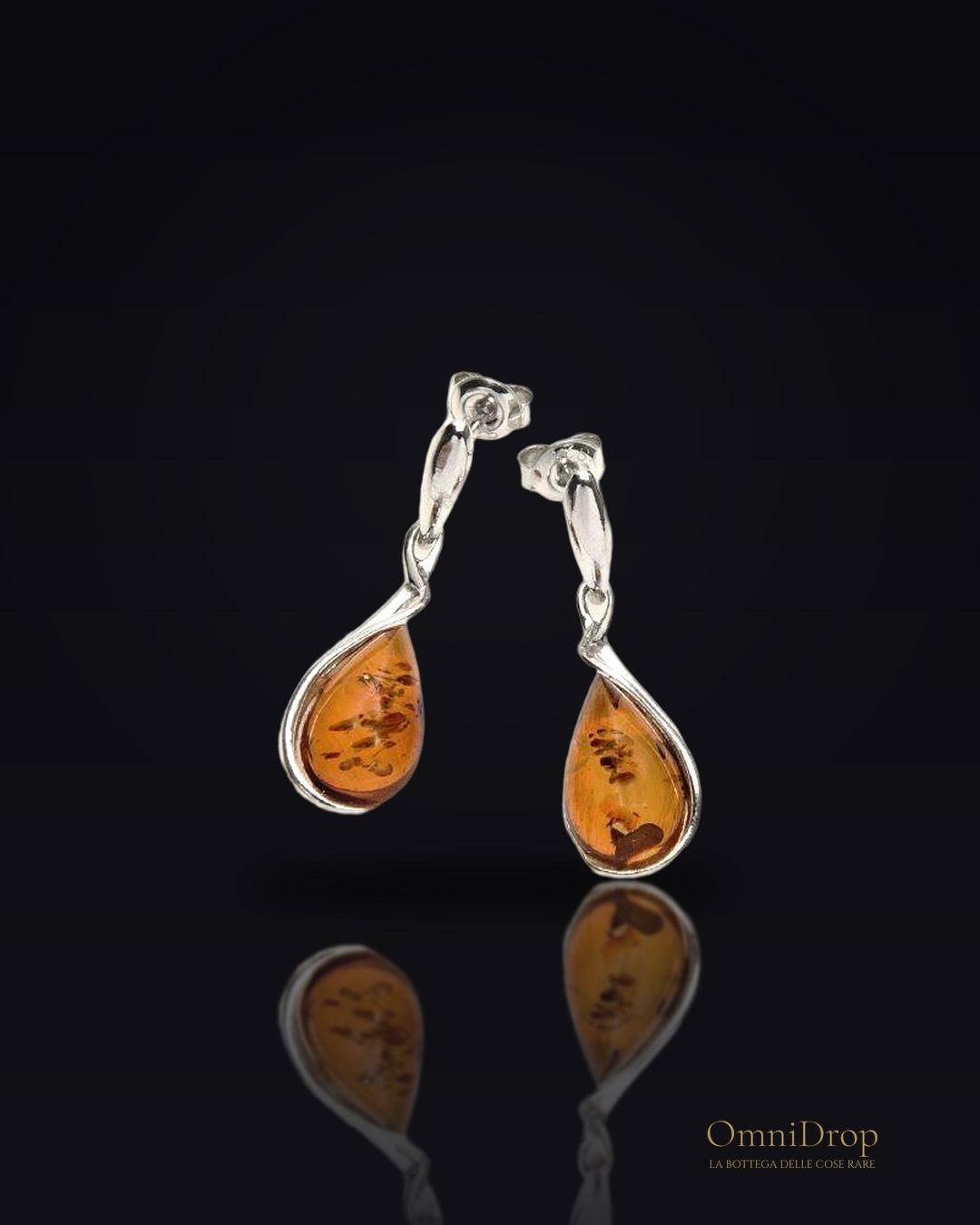 Orecchini pendenti in argento rodiato con goccia di ambra cognac, per custodire la luce
